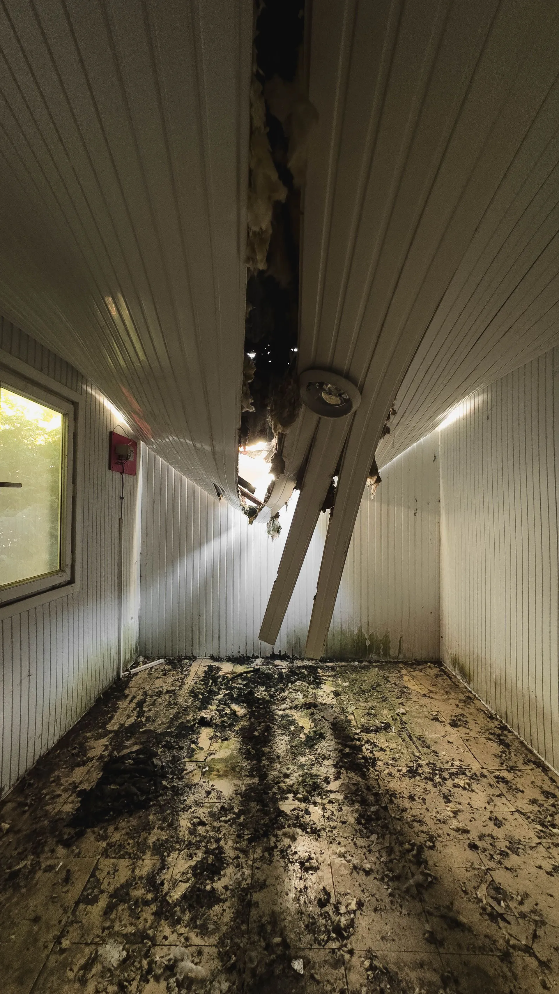 Ceiling collapse and debris across the floor before restoration