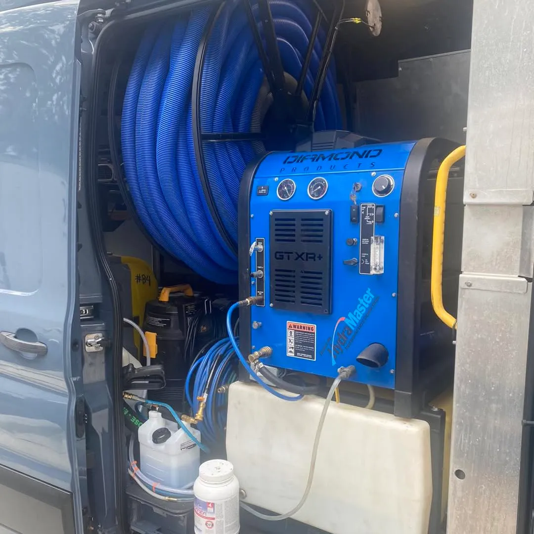 A truck-mounted carpet extractor and hose reel mounted inside a Matrix van