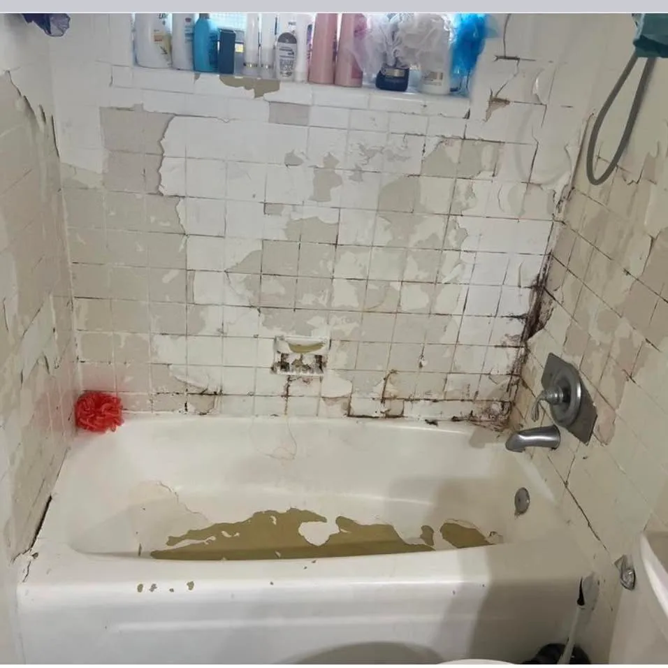 A tub and tile surround stripped back before refinishing