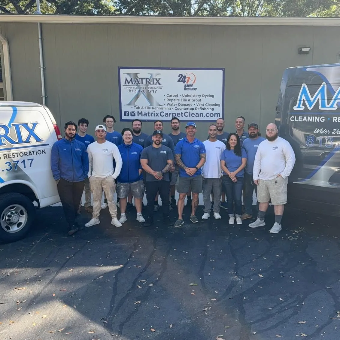 The Matrix Restoration crew outside the shop, between two branded vans